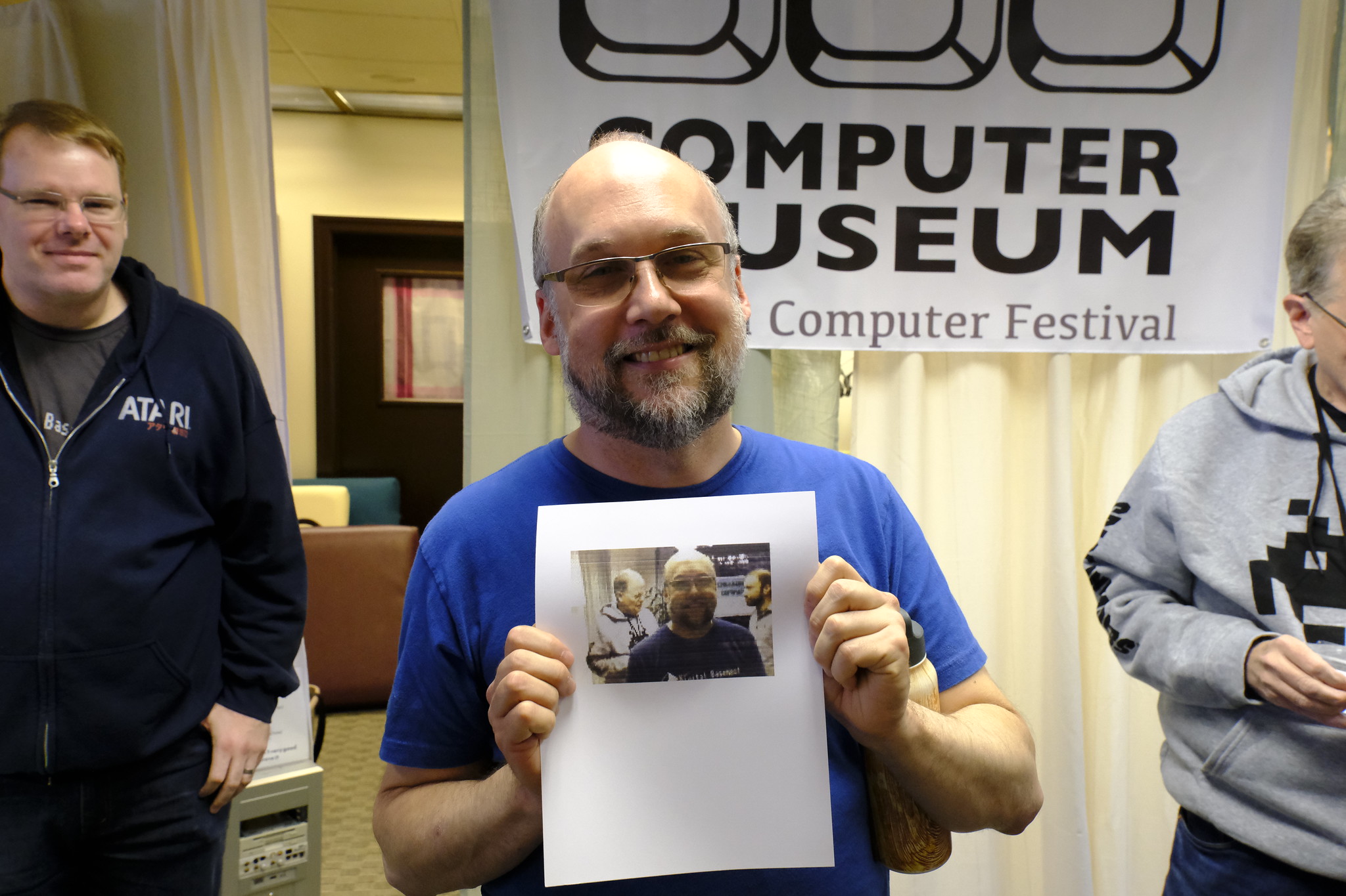 Adrian's Digital Basement holding up a color print of himself